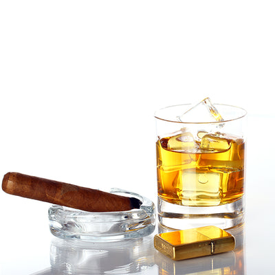כוס זכוכית עם וויסקי וקוביות קרח סיגר גורקה סלר רזרב 12 שנה פלטינום סולר מצת צהובה ומאפרת